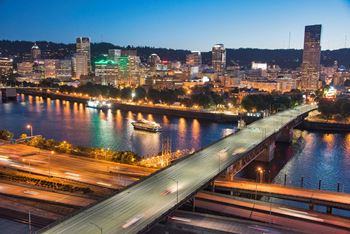 View of city and bridge over river at night